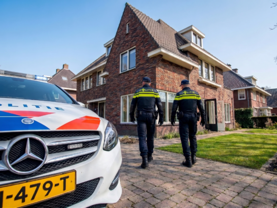 Nederlands politiewagen staat voor woning, twee agenten een reageren op een inbraak